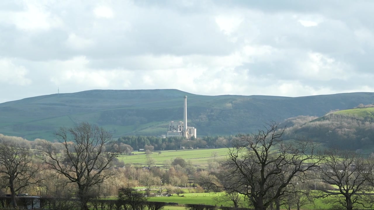 Großer Schornstein eines Zementwerks beeinträchtigt die ländliche Landschaft des Peak District.