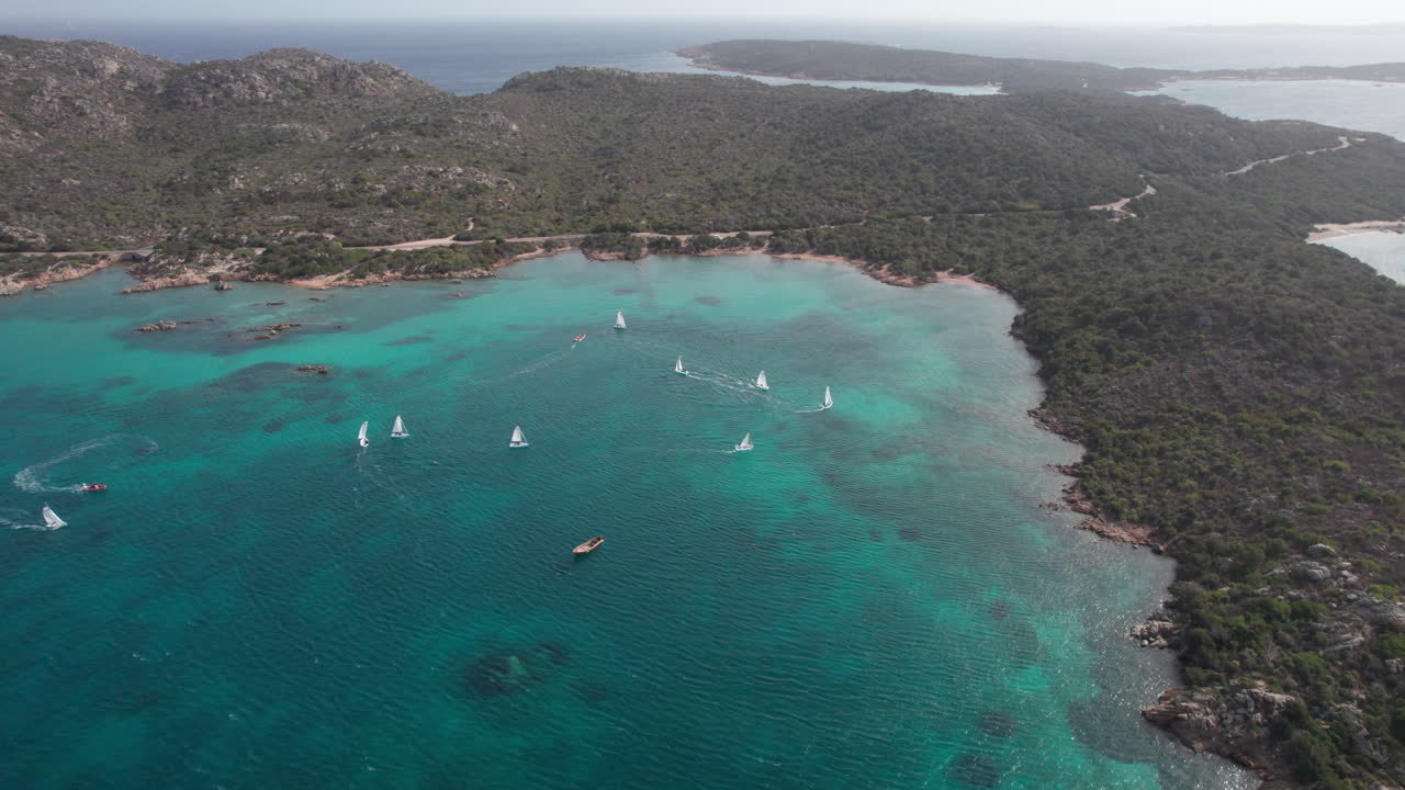 Vista aérea cinematográfica de hermosos veleros navegando sobre el mar de la isla de Caprera en Cerdeña