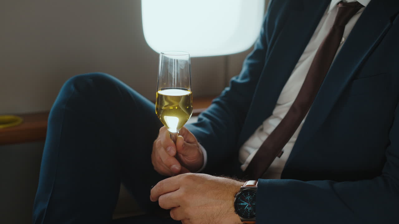 Man in suit drinking champagne in private jet