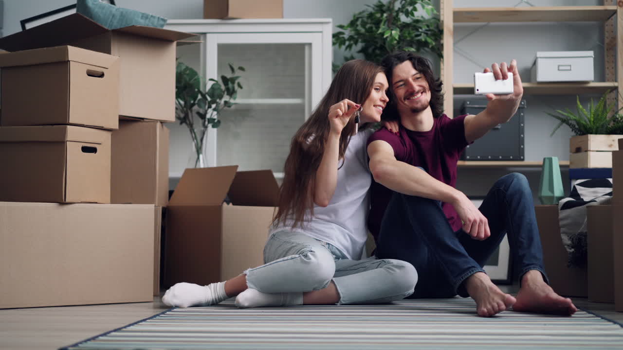 Pareja tomándose una selfie en su nuevo apartamento