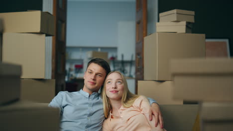 newlyweds moving new flat enjoying own property closeup. couple sitting on couch