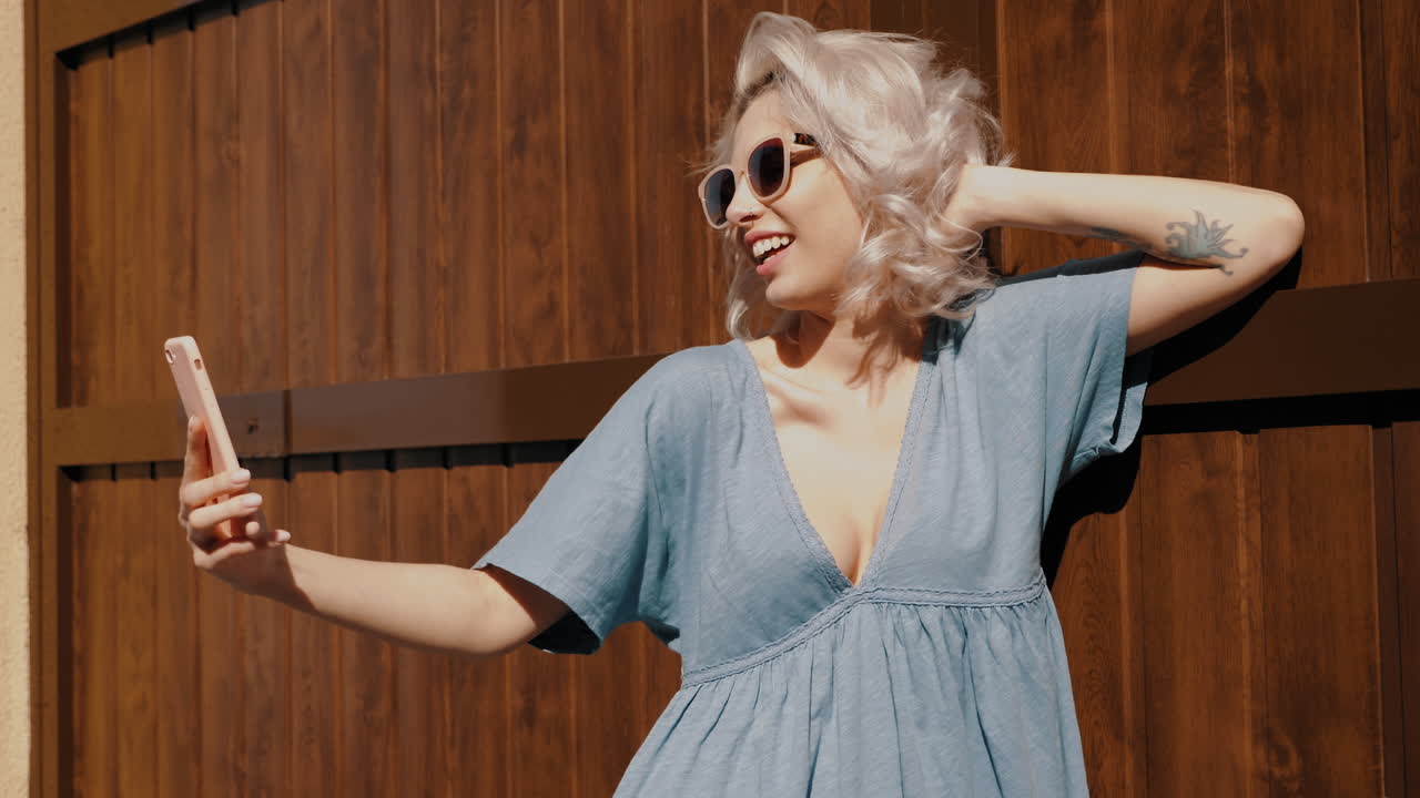 Молодая женщина делает селфи на открытом воздухе.