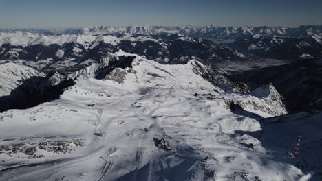 Panorámica-Aérea-Del-Paisaje-Montañoso-Nevado-Iluminado-Por-El-Sol-En-Austria,-Europa