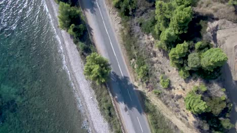 Toma-Aérea,-Camino-Desde-Lo-Alto-A-La-Playa-Con-Autos-Que-Pasan