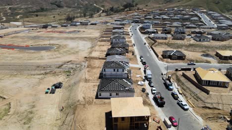 Circling-drone-view-of-a-house-under-construction-in-Spring-Mountain-Ranch,-Riverside,-CA,-amid-a-mix-of-vacant-plots,-homes-in-progress,-and-finished-residences