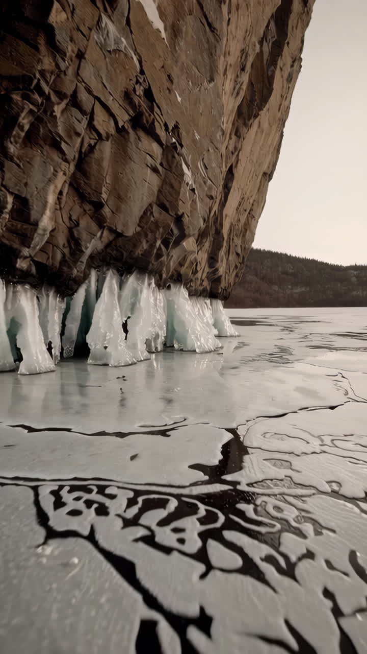 Ice Formations at the Base of a Cliff on a Frozen Lake