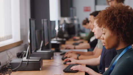 group of college students with tutor studying computer design sitting at monitors in classroom