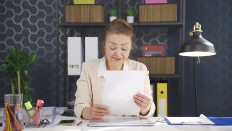 mujer de negocios regocijándose con los resultados positivos del papeleo.
