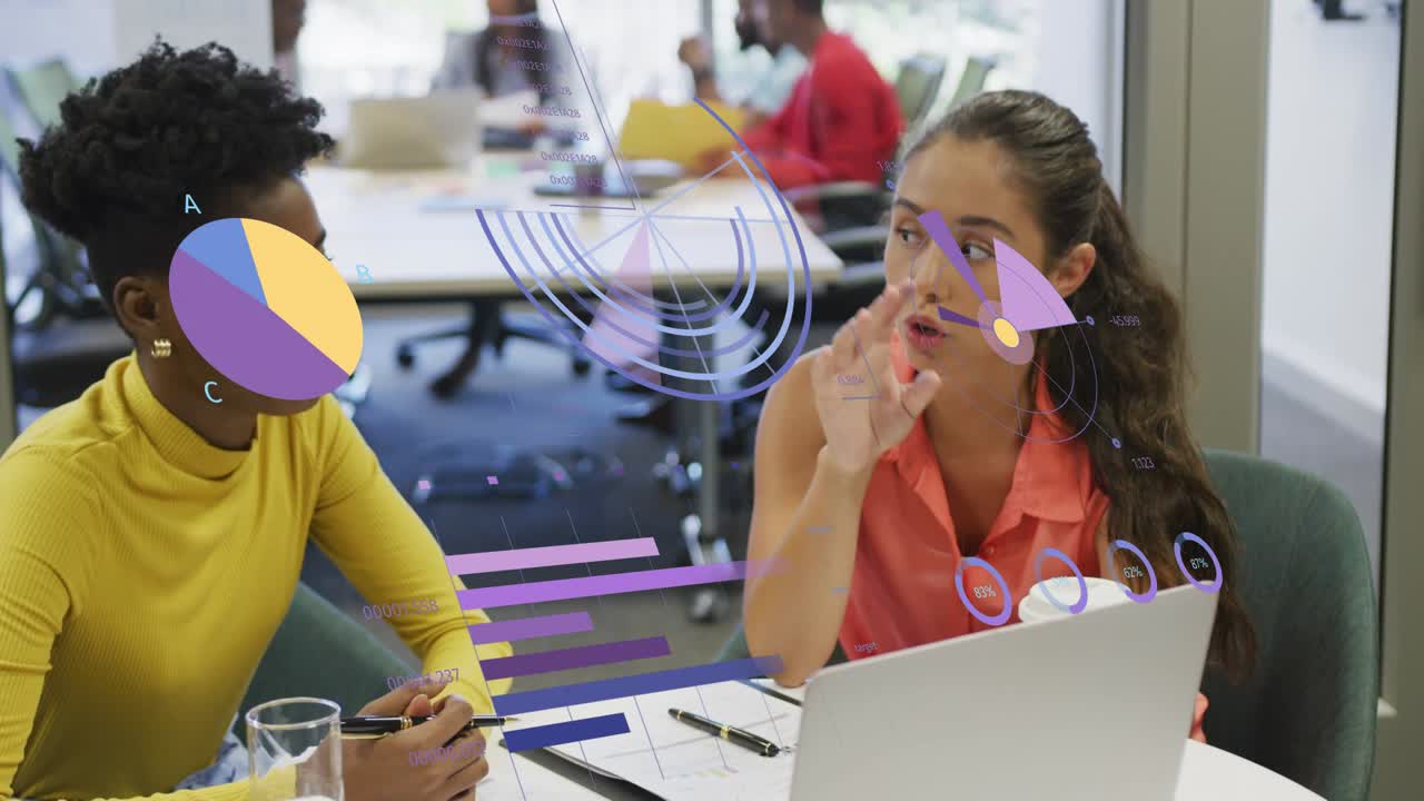Right woman reaching laptop showing business AR charts sliding paper, left peer leaning noting data