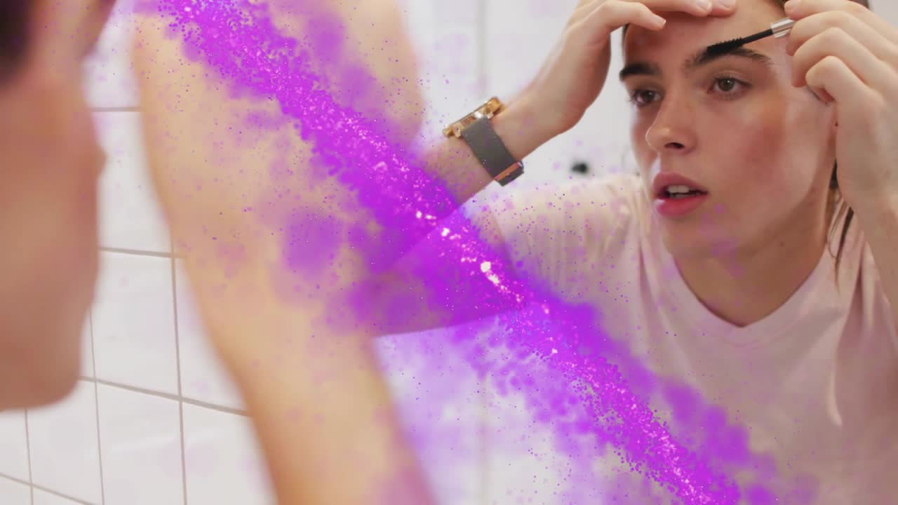 Woman raising brush, brushing eyebrows at mirror, purple particles sweeping across glass for beauty