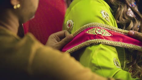 an asian bride have a band on her arm for the good wishes and blessings