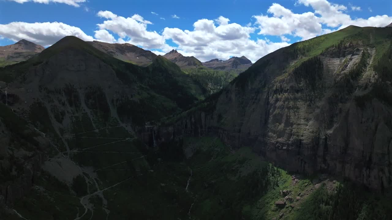 Yankee Boy Basin Colorado Black Bear Pass Road dirt road 4wd hiking blue sky cliffside valley aerial drone Ouray Ridgway Telluride summer Box Canyon Bridal Veil Falls Aspen Forest pan left