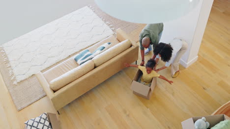 New-house,-box-and-girl-child-playing-with-parents
