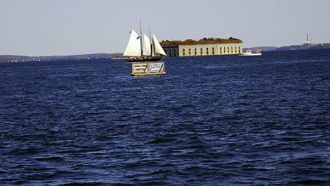 historical fort gorges and sailboat in casco bay near portland, maine