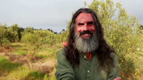 portrait of happy man standing with arms crossed in olive farm 4k