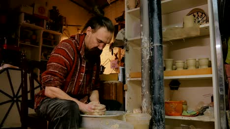 professional male potter making mug in pottery workshop