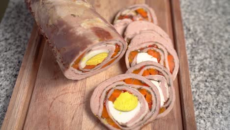 slices of stuffed flank steak arranged on a wooden cutting board - close up