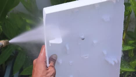 limpieza de un panel de plástico blanco con una lavadora a presión
