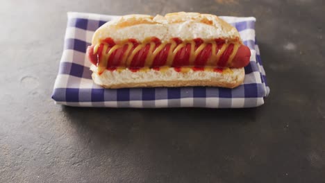 video of hot dog with mustard and ketchup on a black surface