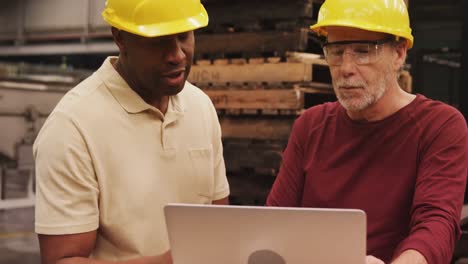 workers discussing over laptop