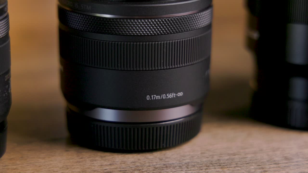 Static shot of Mirrorless camera lens sitting on a table, close up details of minimum focus distance