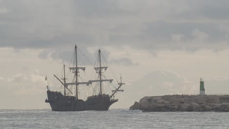 16th century galleon andalucia replica ship arriving at port in a beautiful cloudy day at sunrise