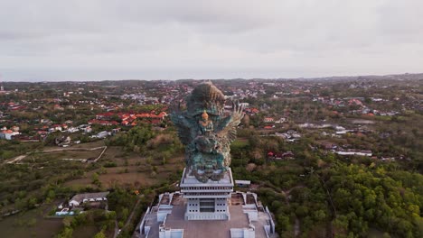 this cinematic drone shot highlights the intricate design and sheer scale of bali's garuda wisnu kencana statue, symbolizing balinese spirituality and standing high above the island landscape