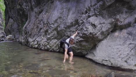 Man-walking-on-creek-in-canyon.