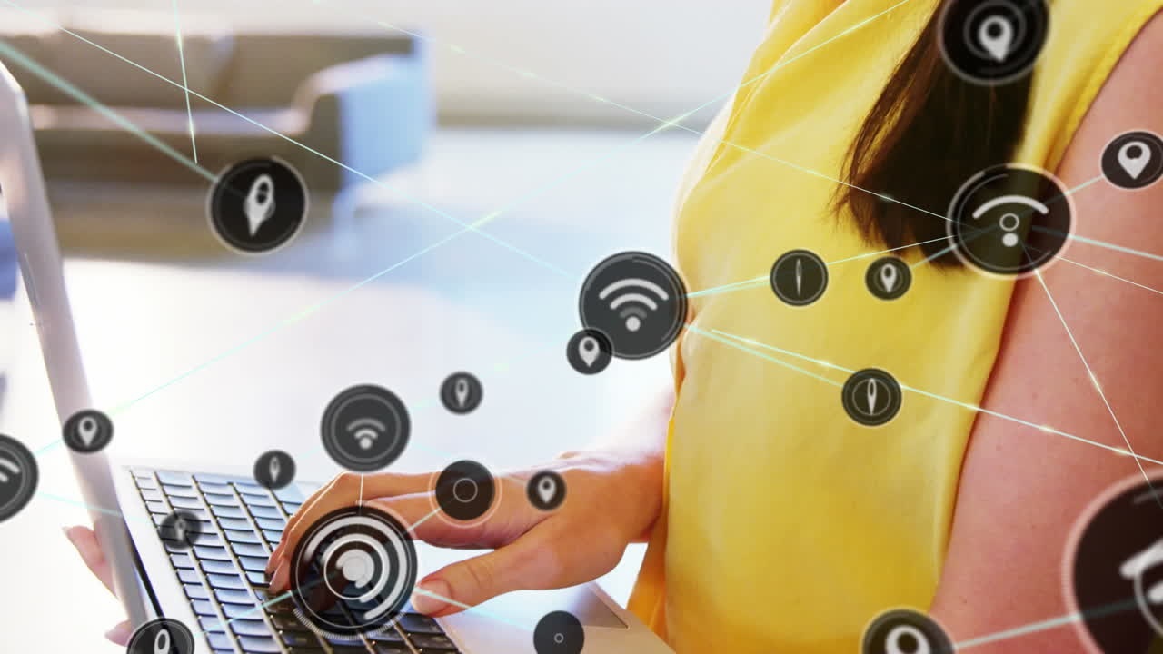 animación de una red de iconos digitales contra una mujer caucásica que usa una computadora portátil en la oficina