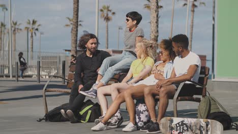 trendy young friends on bench on street