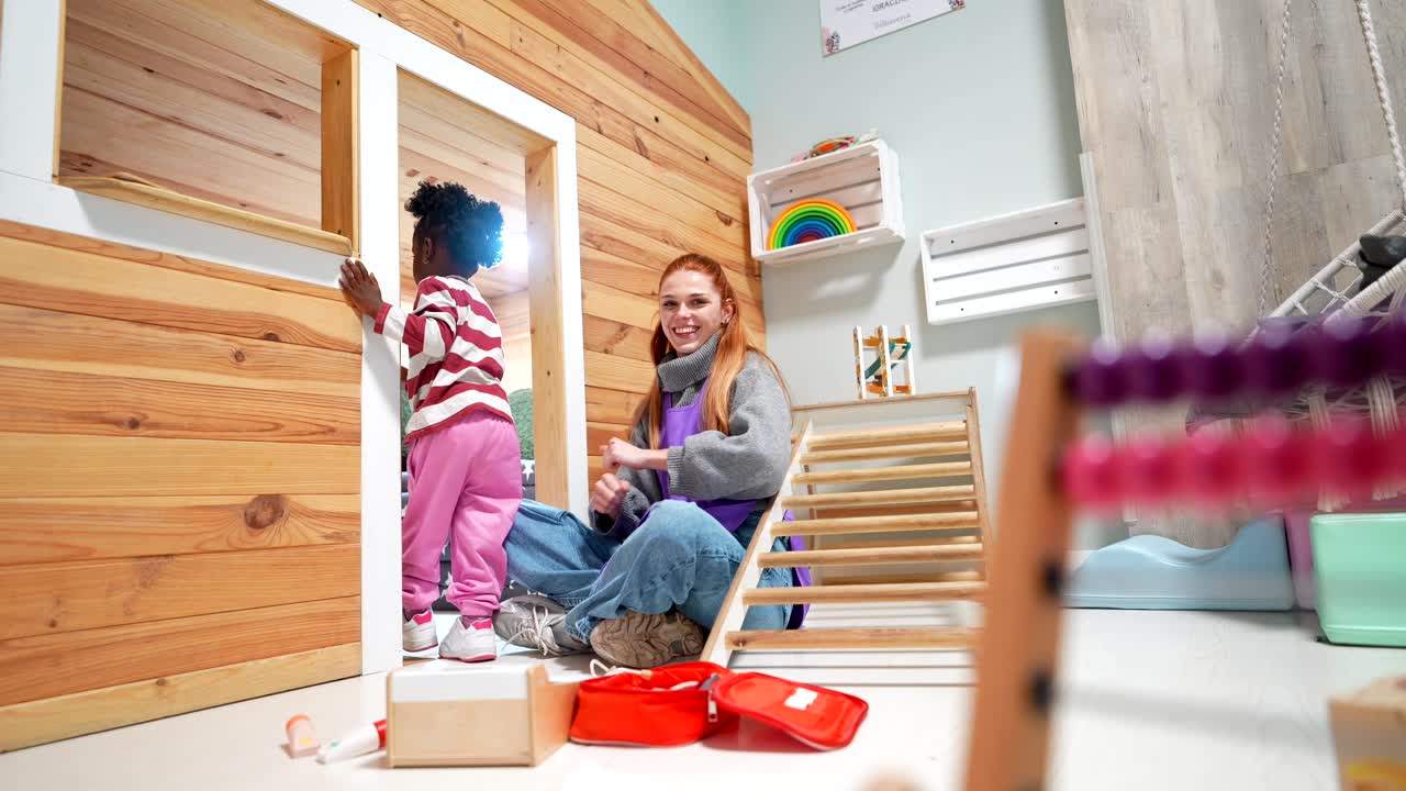 Happy Woman and Child Playing with Toys in a Bright Playroom