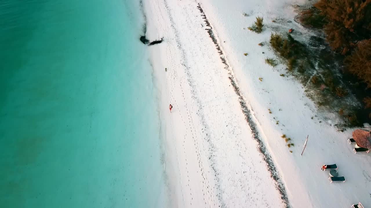 Smooth tilt up reveal fly forwards drone shot over a dream beach