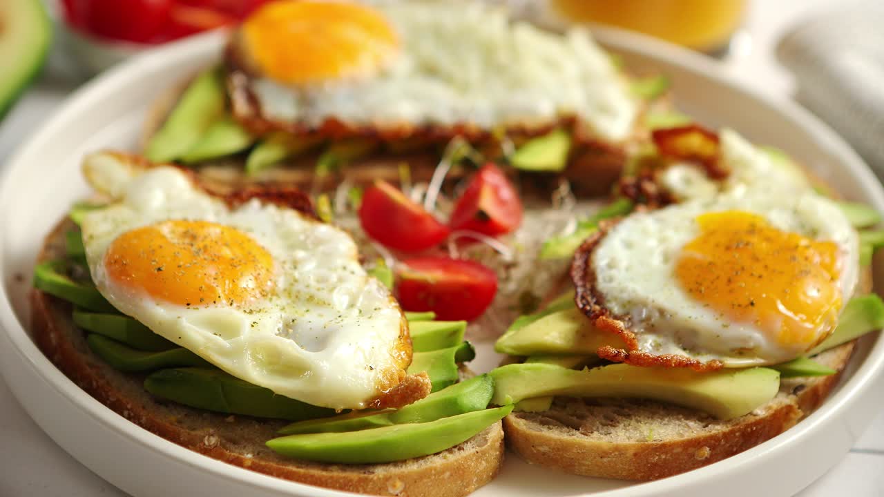 얇게 썬 아보카도 샌드위치와 달걀 프라이를 곁들인 건강한 아침 식사