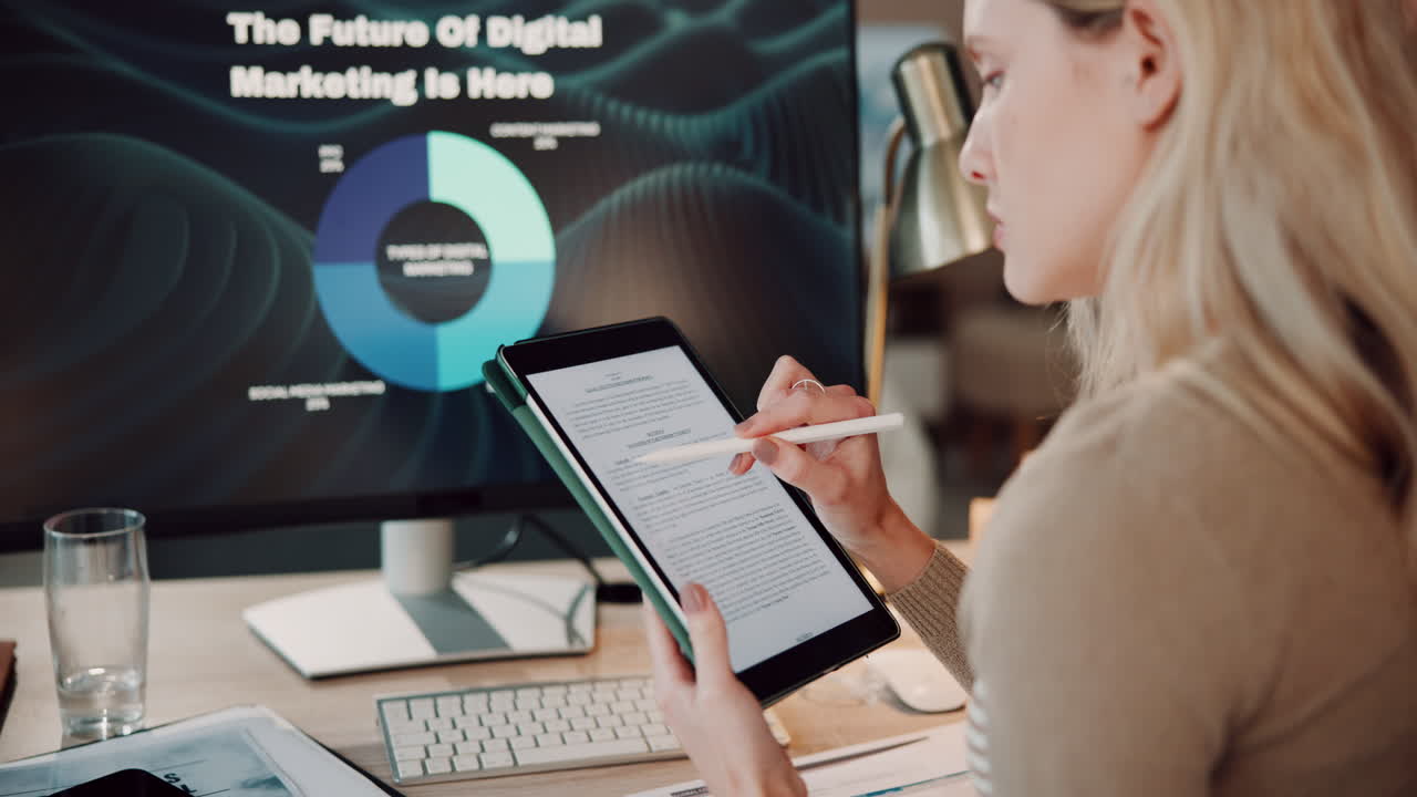 Woman working at her desk, analyzing digital marketing data
