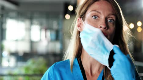 Close-up-of-female-physician-taking-off-medical-mask-and-goggles-and-looking-at-camera