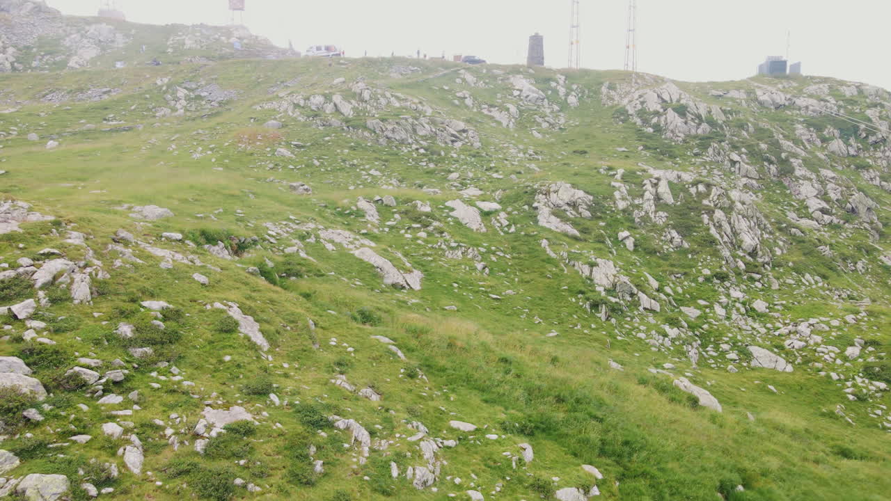 вид снизу на пассо сан марко в итальянских альпах с автомобилями и туристами на вершине в туманный день на севере италии - дрон с воздуха, съемка с низкого ракурса