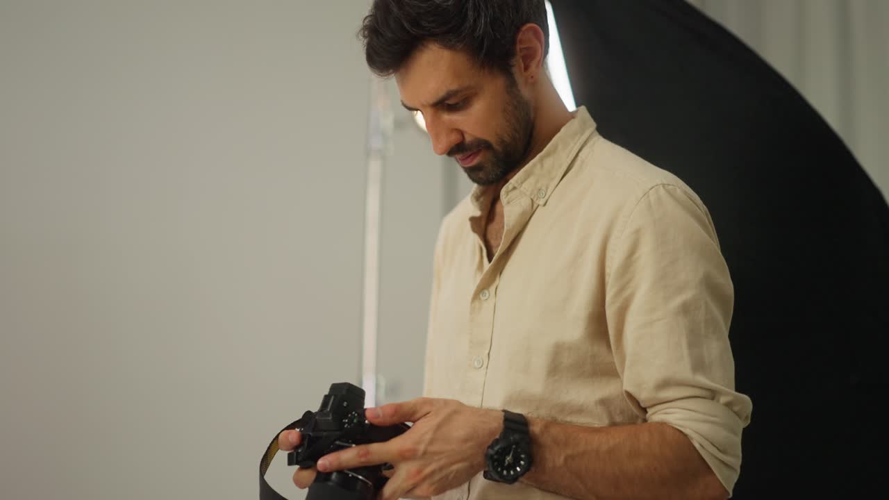 un fotógrafo mirando su cámara en un estudio