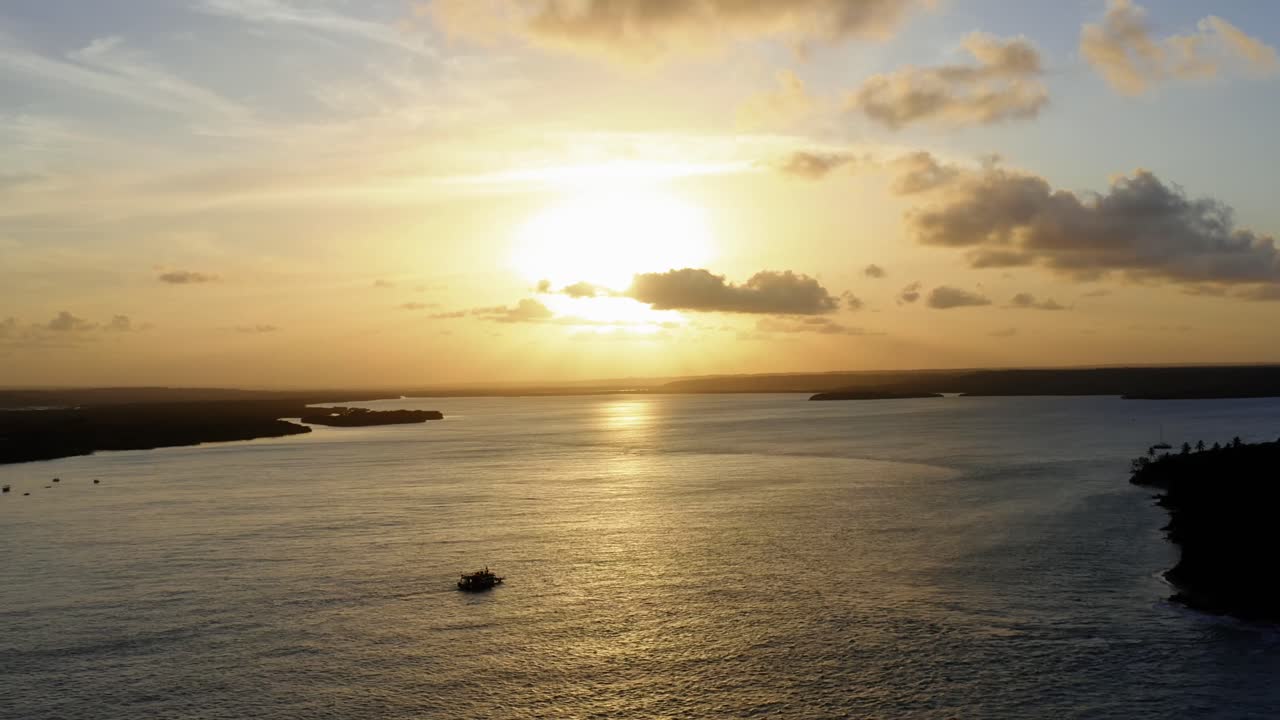 Amazing aerial drone shot of a gorgeous golden sunset reflecting onto a massive amazonian river in Tibau do Sol near Pipa in Northeastern Brazil on a warm summer day