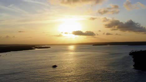 amazing aerial drone shot of a gorgeous golden sunset reflecting onto a massive amazonian river in tibau do sol near pipa in northeastern brazil on a warm summer day