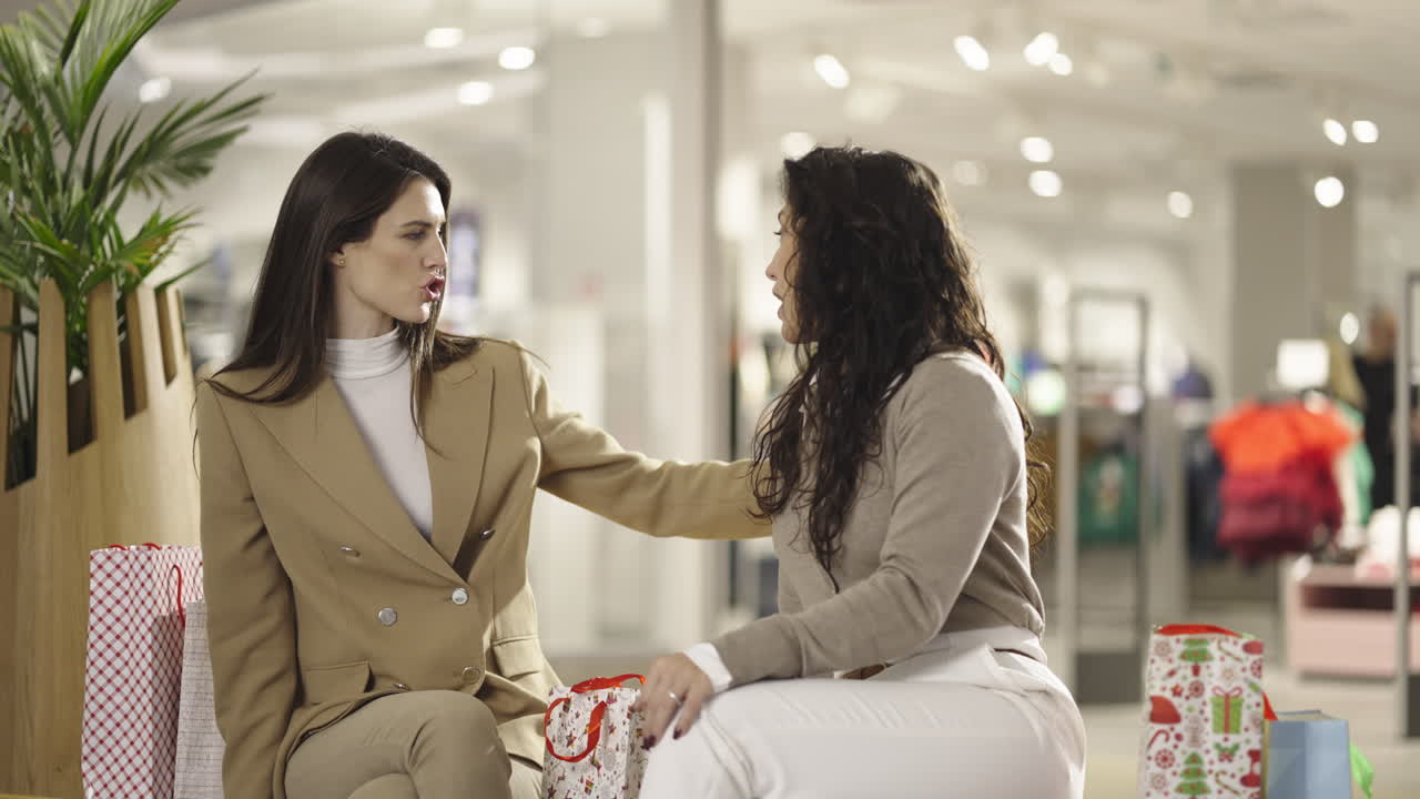 Two women talking and shopping in a mall