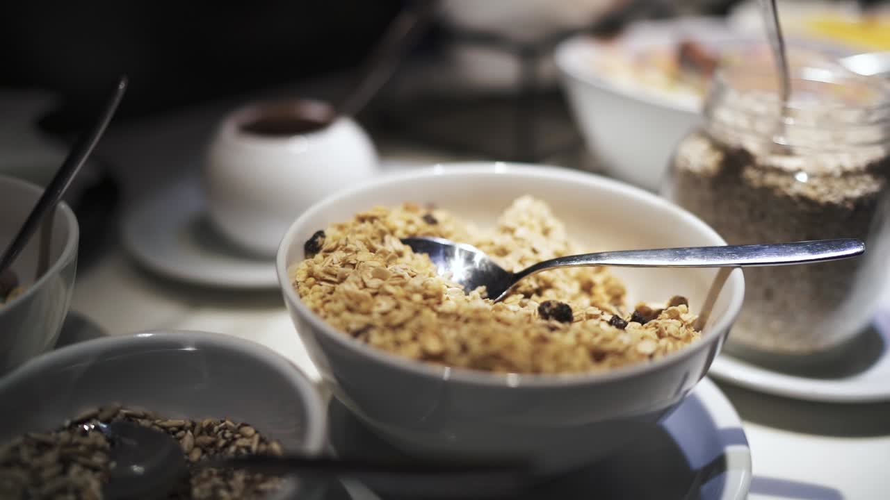 Super slow closeup detailed shot of oatmeal filled white bowls at hotel breakfast, with very shallow depth of field