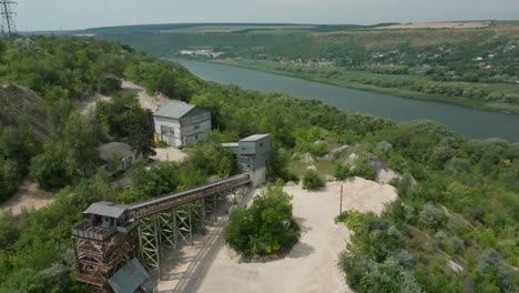 a-plant-for-the-extraction-of-fossil-gold,-which-is-located-on-the-edge-of-the-river-near-the-slope-between-dense-green-trees