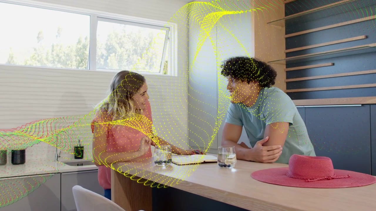 Woman reaching with phone man reacting flipping planner planning as yellow tech dots flowing