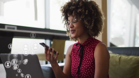 Animation-of-media-icons-over-african-american-businesswoman-in-office