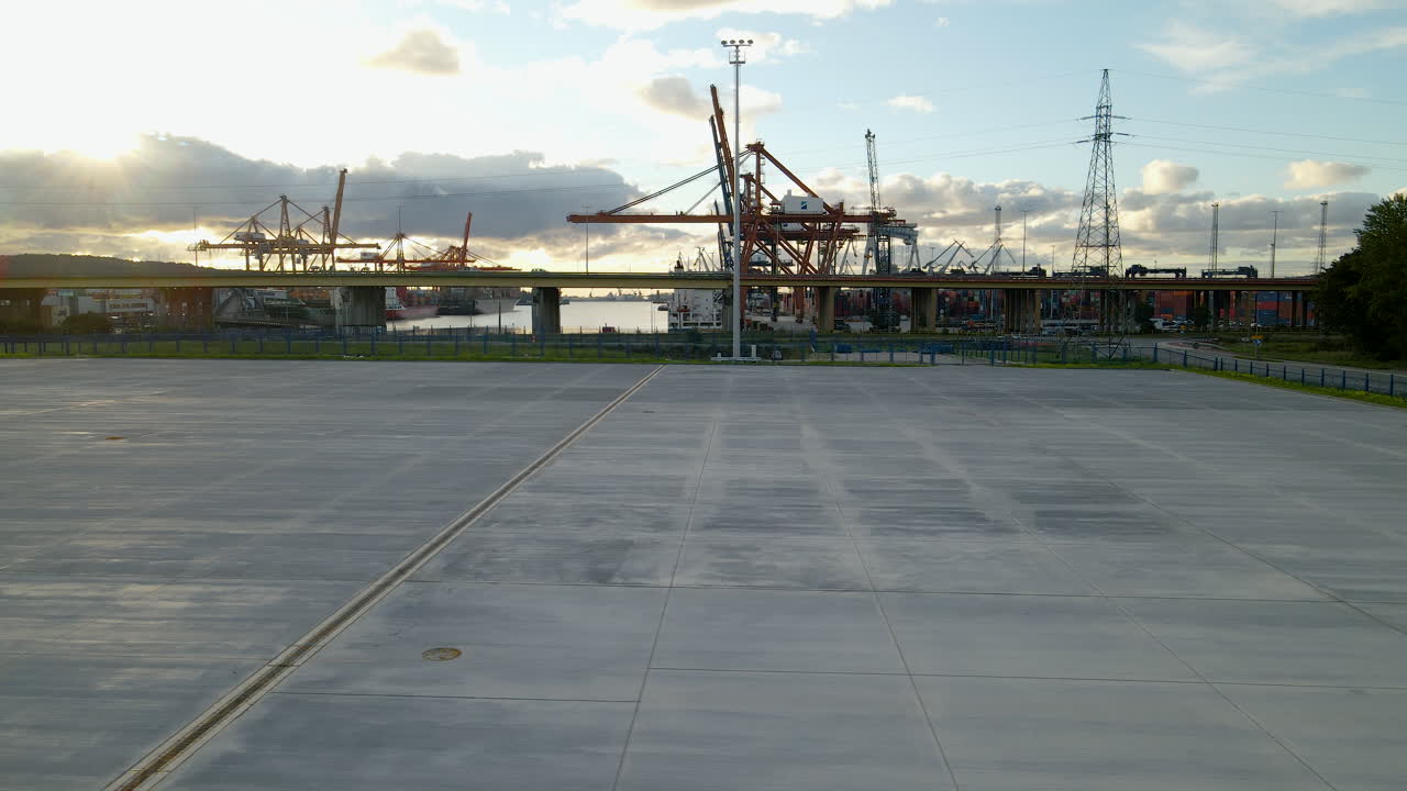 폴란드 그디니아(gdynia)에서 해가 질 때 크레인이 있는 산업용 컨테이너 조선소의 트럭 운송