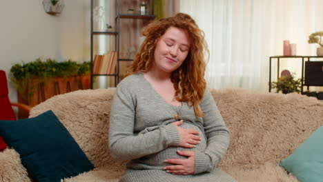 pregnant young woman talking to belly at home gently touching bonding with baby emotional connection
