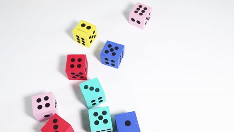 hand releasing colorful dice against white background