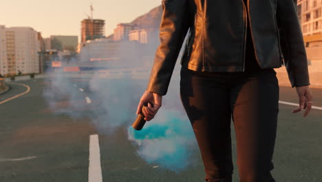 confident woman holding smoke grenade walking in city street at sunrise rebellious female activist protesting