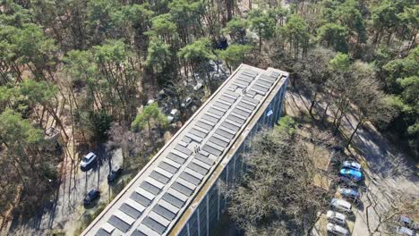 Beautiful-aerial-of-photovoltaic-solar-panels-on-rooftop-of-old-apartment-building-on-a-sunny-day