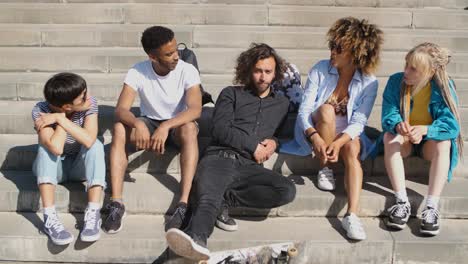 young stylish friends on street steps